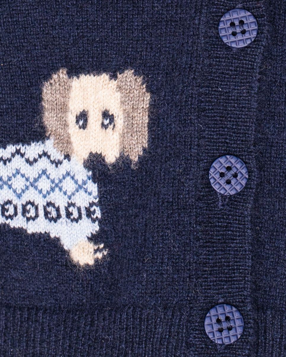 Close up of navy blue sweater with a dog pattern and buttons on a dark background
