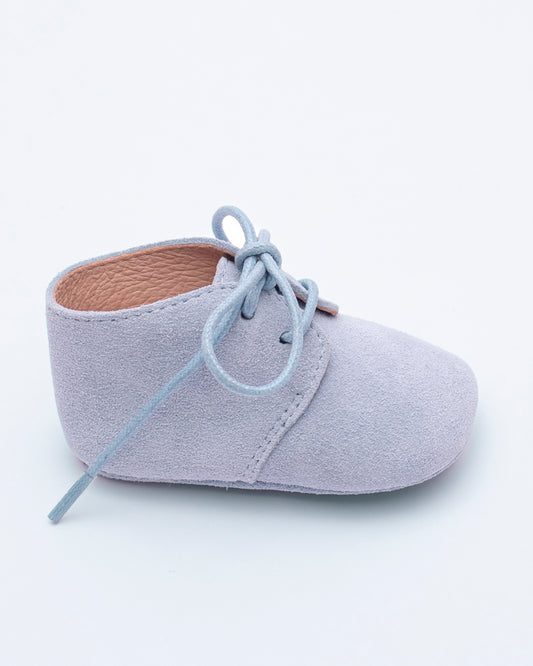 Light blue baby shoe with laces on a white background