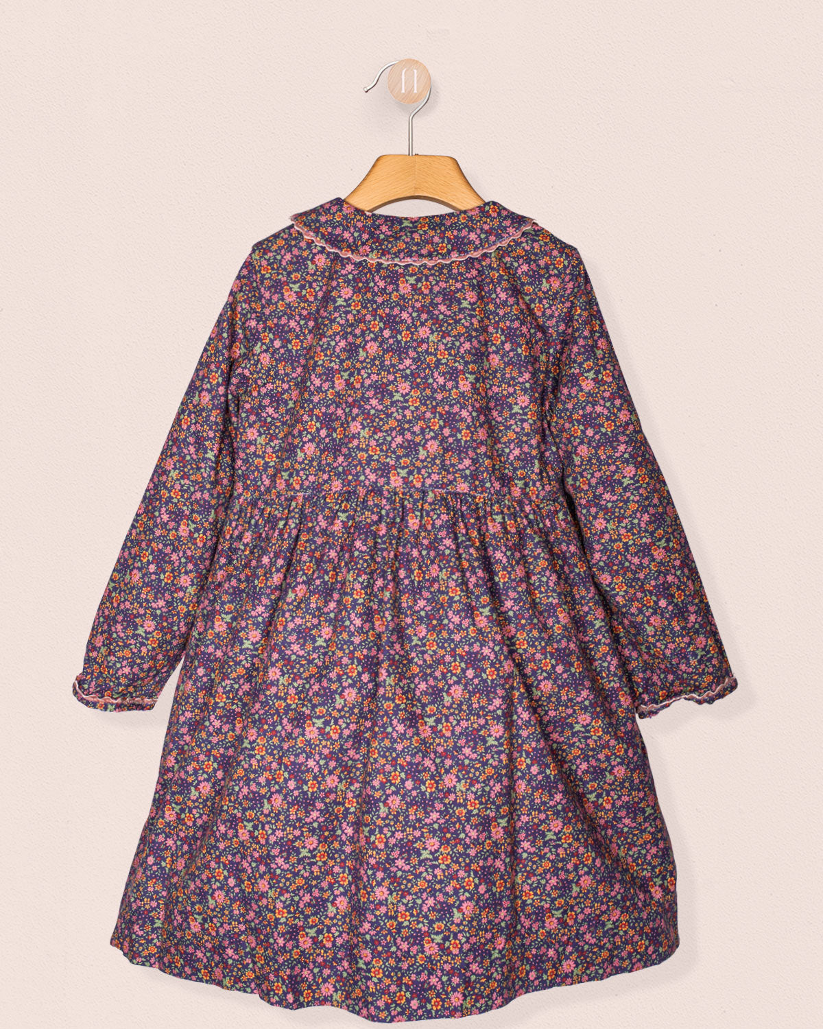 Floral dress on a hanger against a beige background