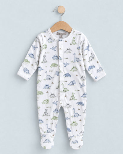 Onesie footie hanging from a wooden hanger with a blue grey background, with blue and green dinosaur motif.