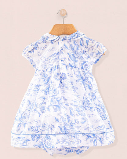 Back view of the Baby Emmy Liberty Delft Blue Dress showing two small back buttons, gentle gathering at the waist, and a matching printed diaper cover peeking underneath the skirt.