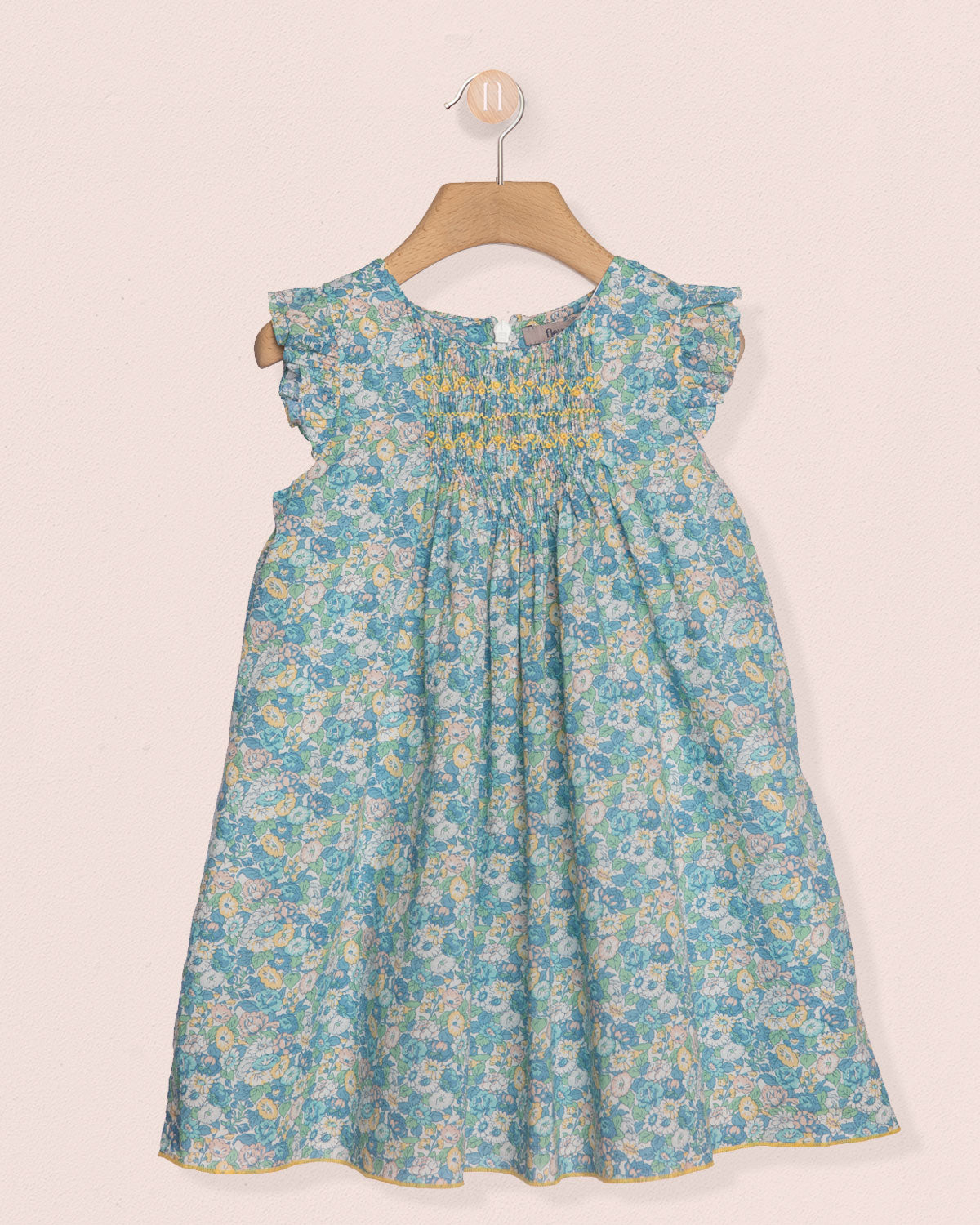 Floral dress on a hanger against a light background