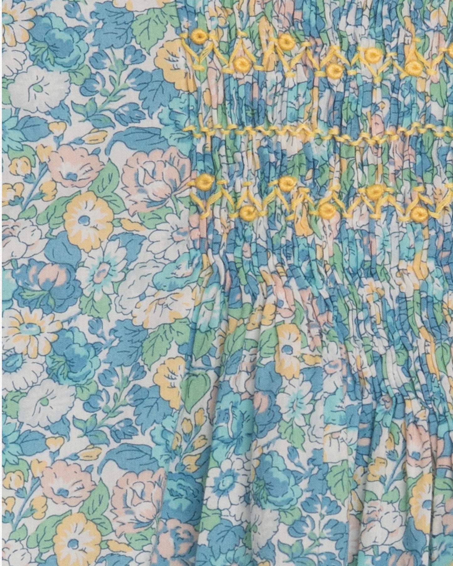 Close up of floral patterned fabric with blue, yellow, and green colors.