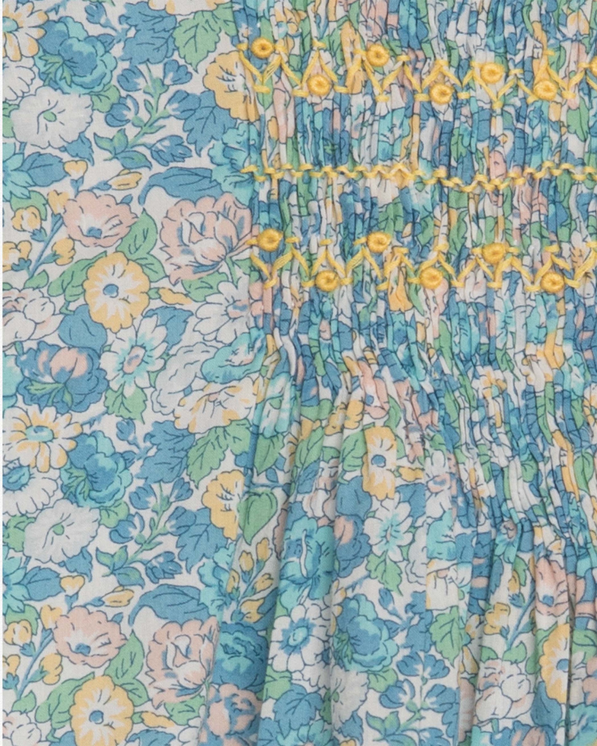 Close up of floral patterned fabric with blue, yellow, and green colors.