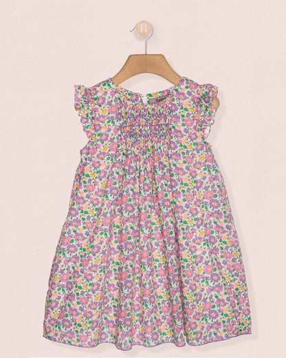 Floral dress on a hanger against a light pink background