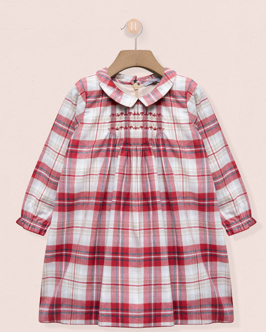 Red and white plaid dress on a hanger against a pink background