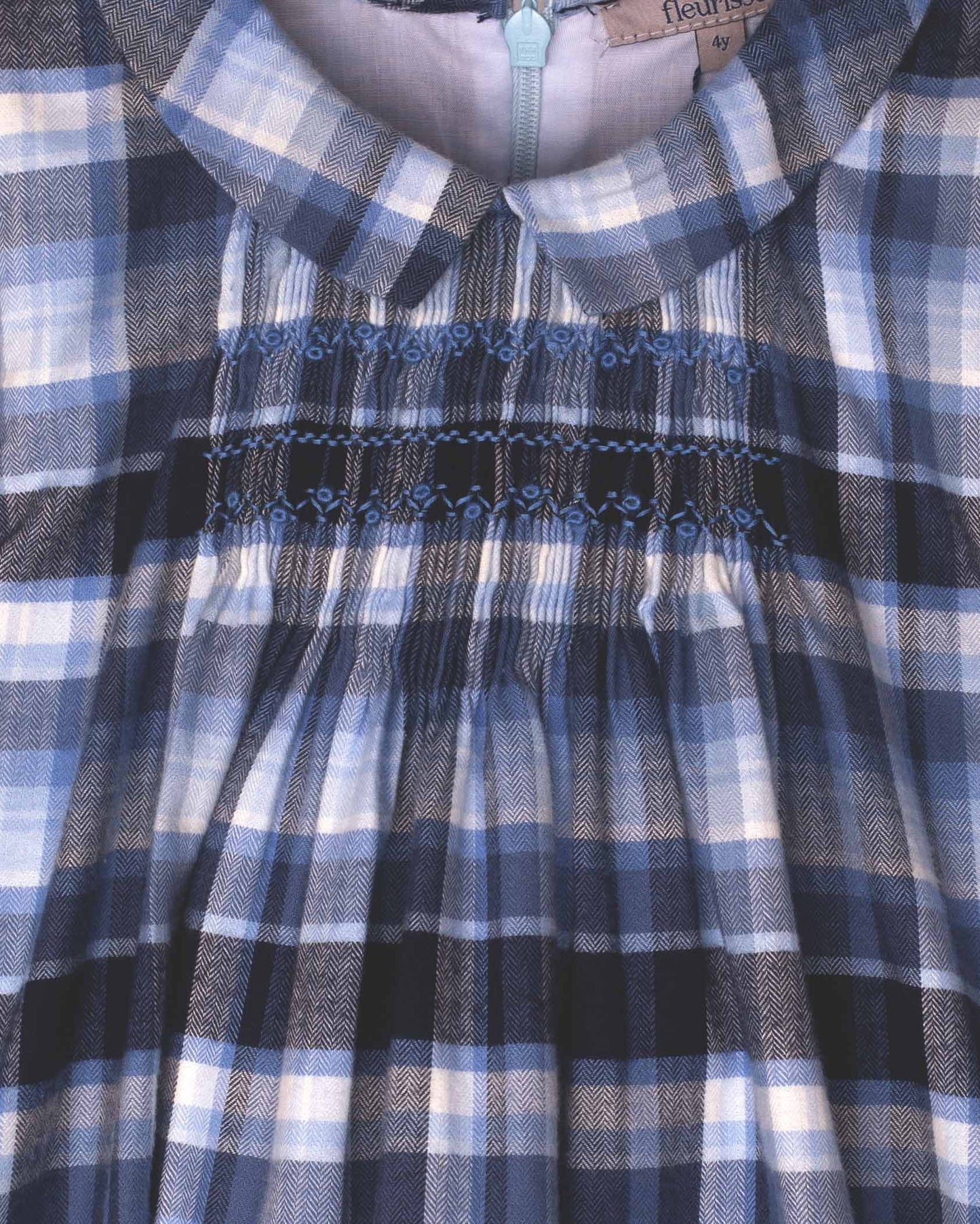 Close-up of a blue and white checkered dress with smocked waistband.