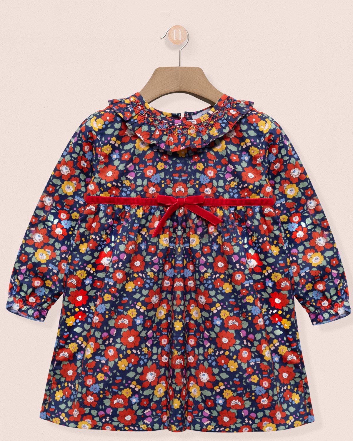 Floral-patterned dress with a red belt on a beige background