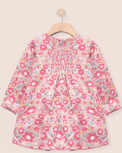 Floral patterned dress on a hanger against a beige background