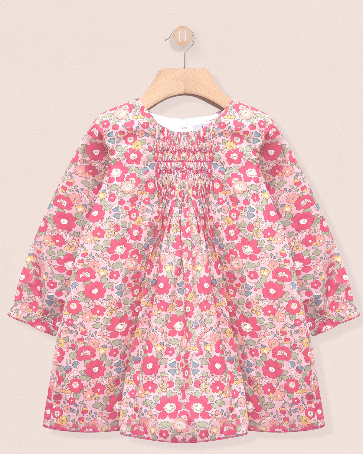 Floral dress on a hanger against a beige background