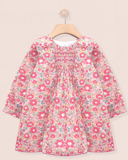 Floral dress on a hanger against a beige background