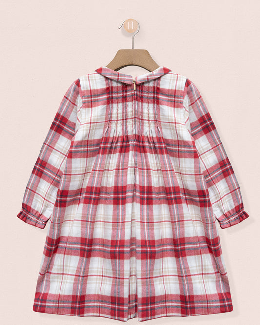 Red and white plaid dress on a hanger against a light pink background