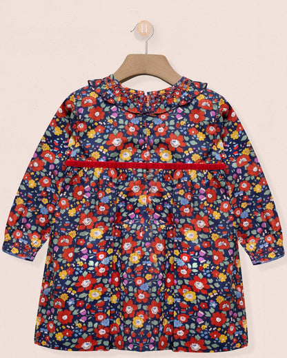 Children's floral dress on a hanger against a beige background