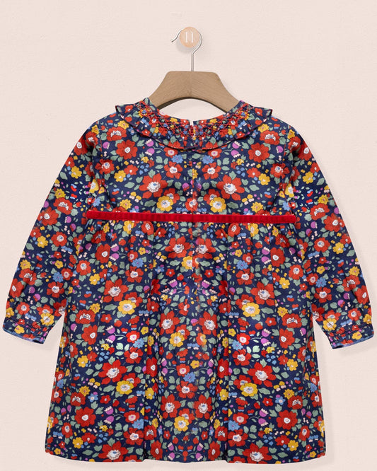 Children's floral dress on a hanger against a beige background