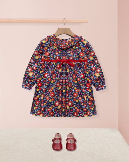 Floral dress with a red belt and matching shoes on a pink background