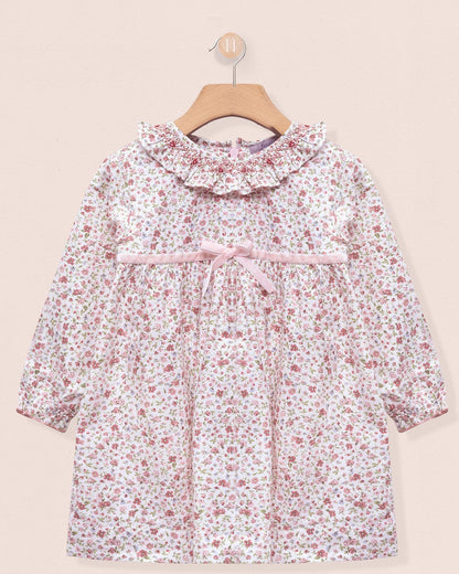 Floral dress on a hanger against a beige background