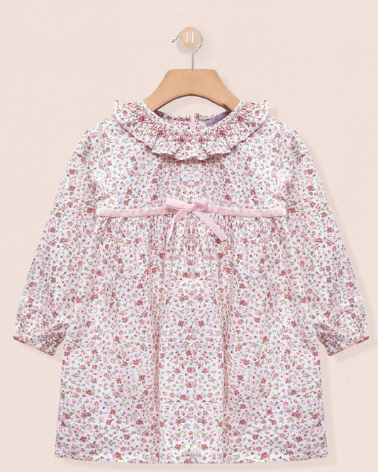 Floral dress on a hanger against a beige background