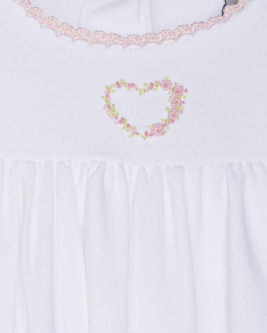White gown with floral heart design and lace trim on a white background