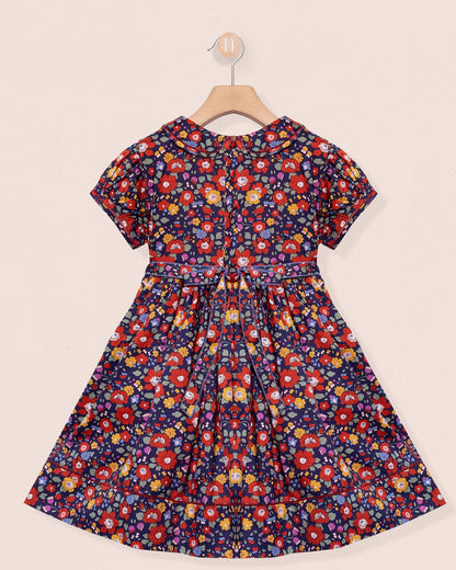 Floral dress on a hanger against a beige background