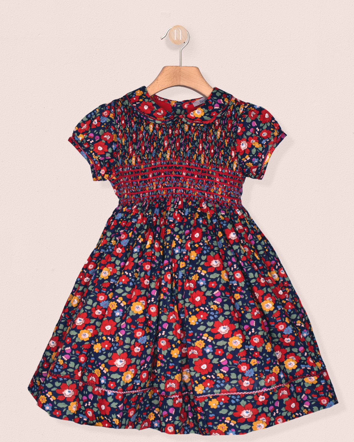 Floral dress on a hanger against a beige background