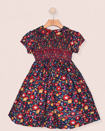 Floral dress on a hanger against a beige background