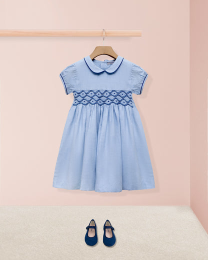 Blue dress with lattice detail on a pink background
