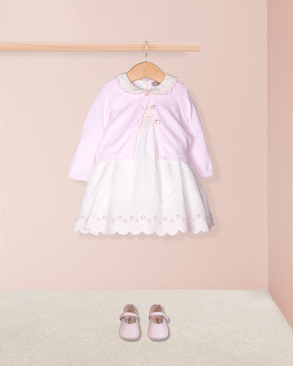 Pink and white dress with matching shoes on a pink background