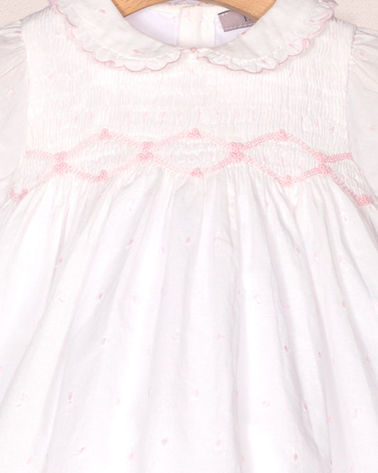 White dress with pink floral embroidery on a white background