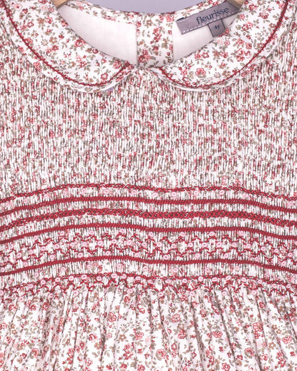 Close-up of a floral dress with smocked waistband and brand label.