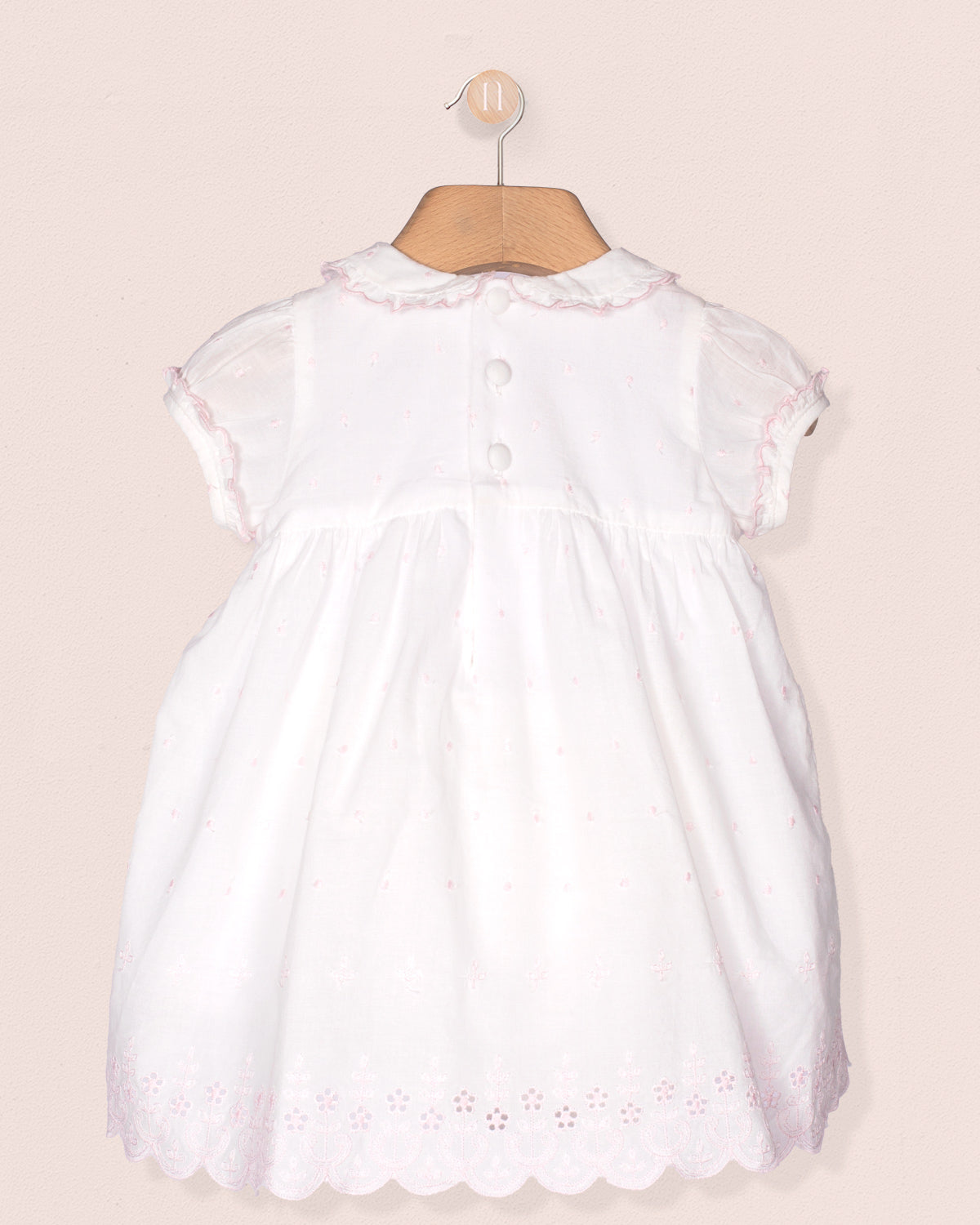 White dress with lace details on a beige background