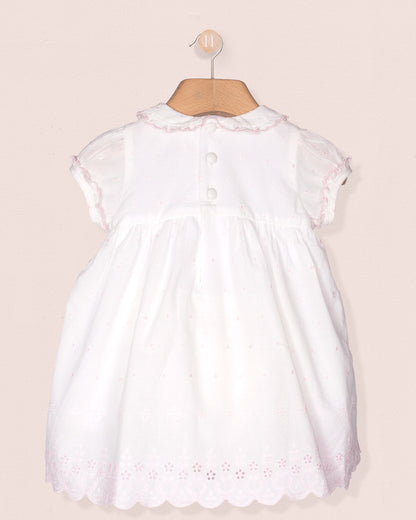 White dress with lace details on a beige background