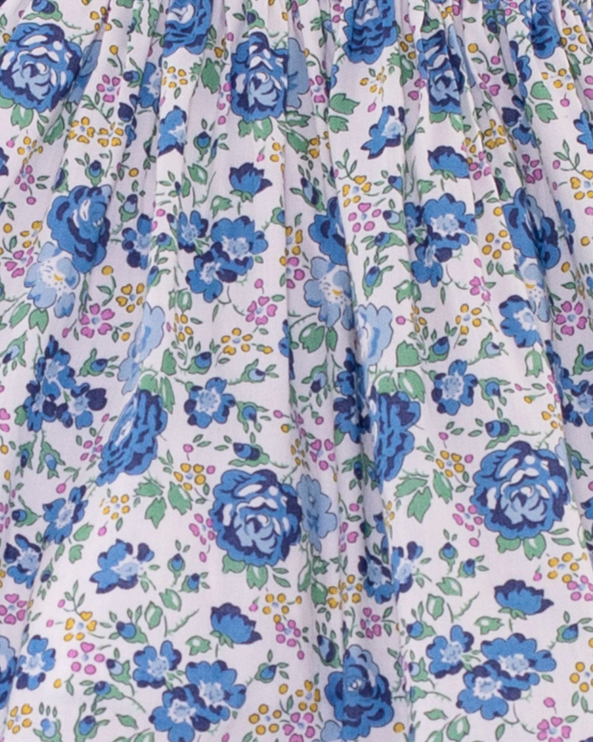 Close-up of Baby Emmy Liberty Blue Rosebud Mini Dress Set fabric, showcasing ditsy floral print with blue roses and intricate entre-deux stitching on the bodice.