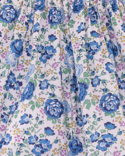 Close-up of Baby Emmy Liberty Blue Rosebud Mini Dress Set fabric, showcasing ditsy floral print with blue roses and intricate entre-deux stitching on the bodice.