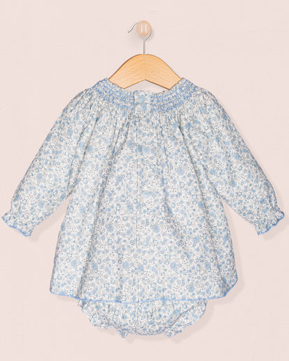 Baby dress with floral pattern on a hanger against a light background
