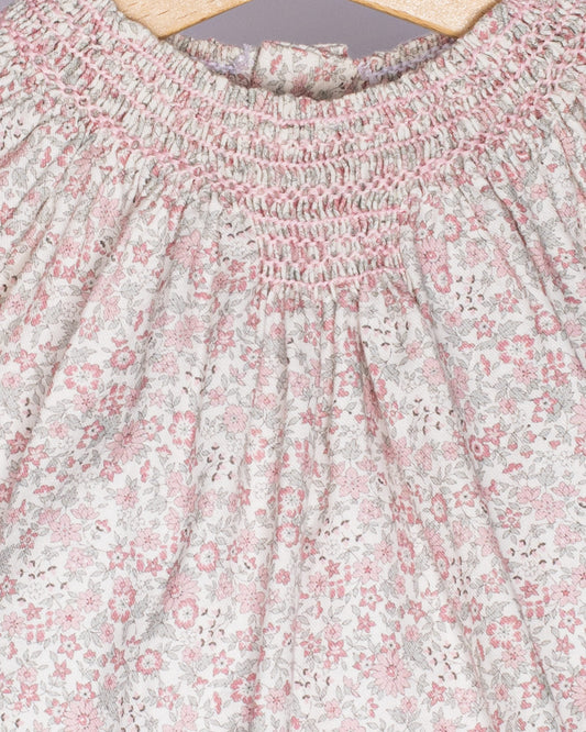 Close-up of a floral patterned fabric with pink and white flowers on a light background.