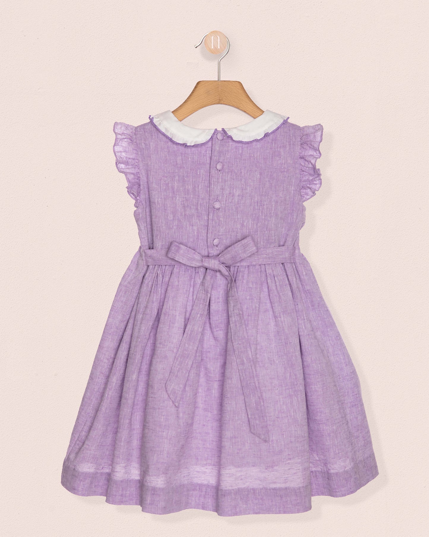 Purple dress with white collar on a beige background