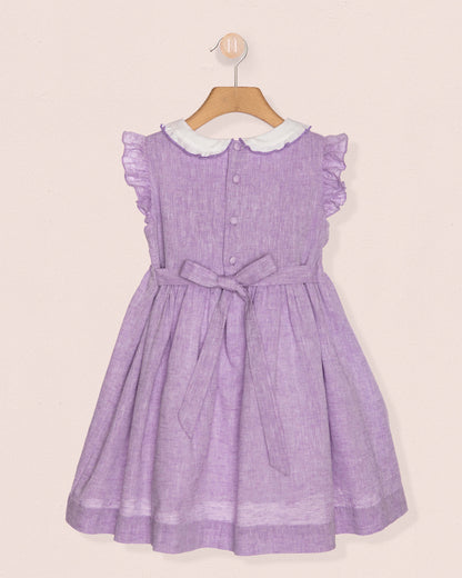 Purple dress with white collar on a beige background