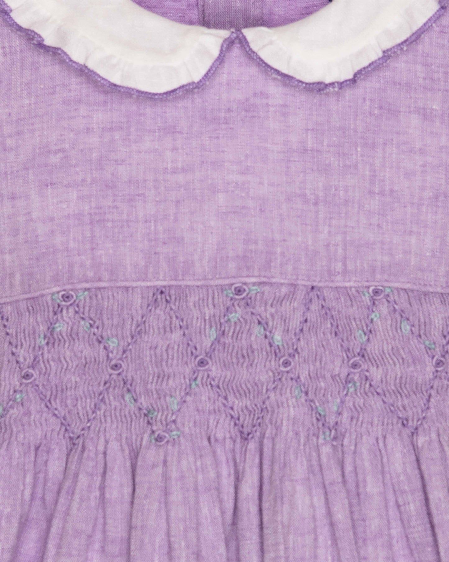 Close-up of a purple dress with white collar and smocked waistband