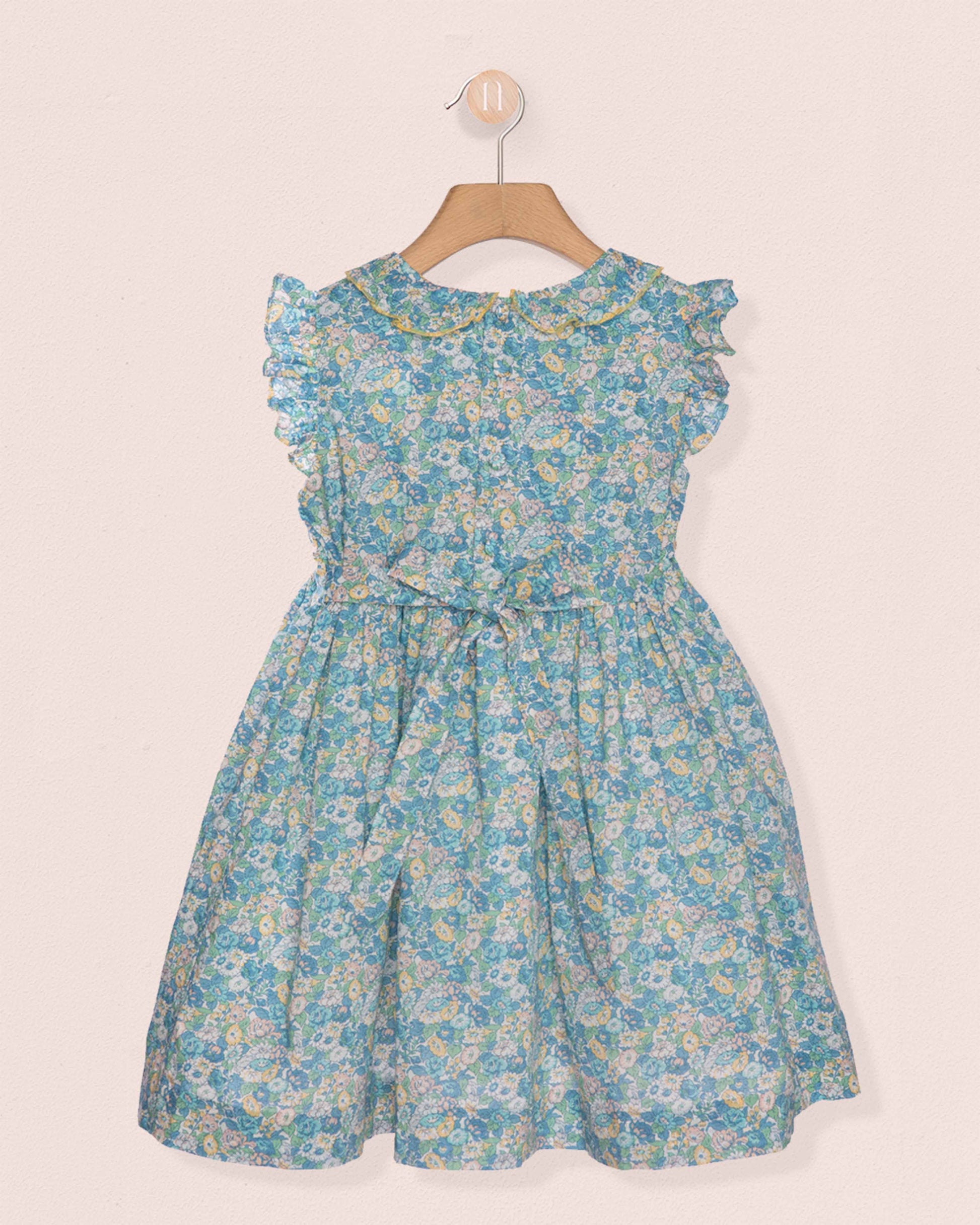 Blue floral dress on a hanger against a white background