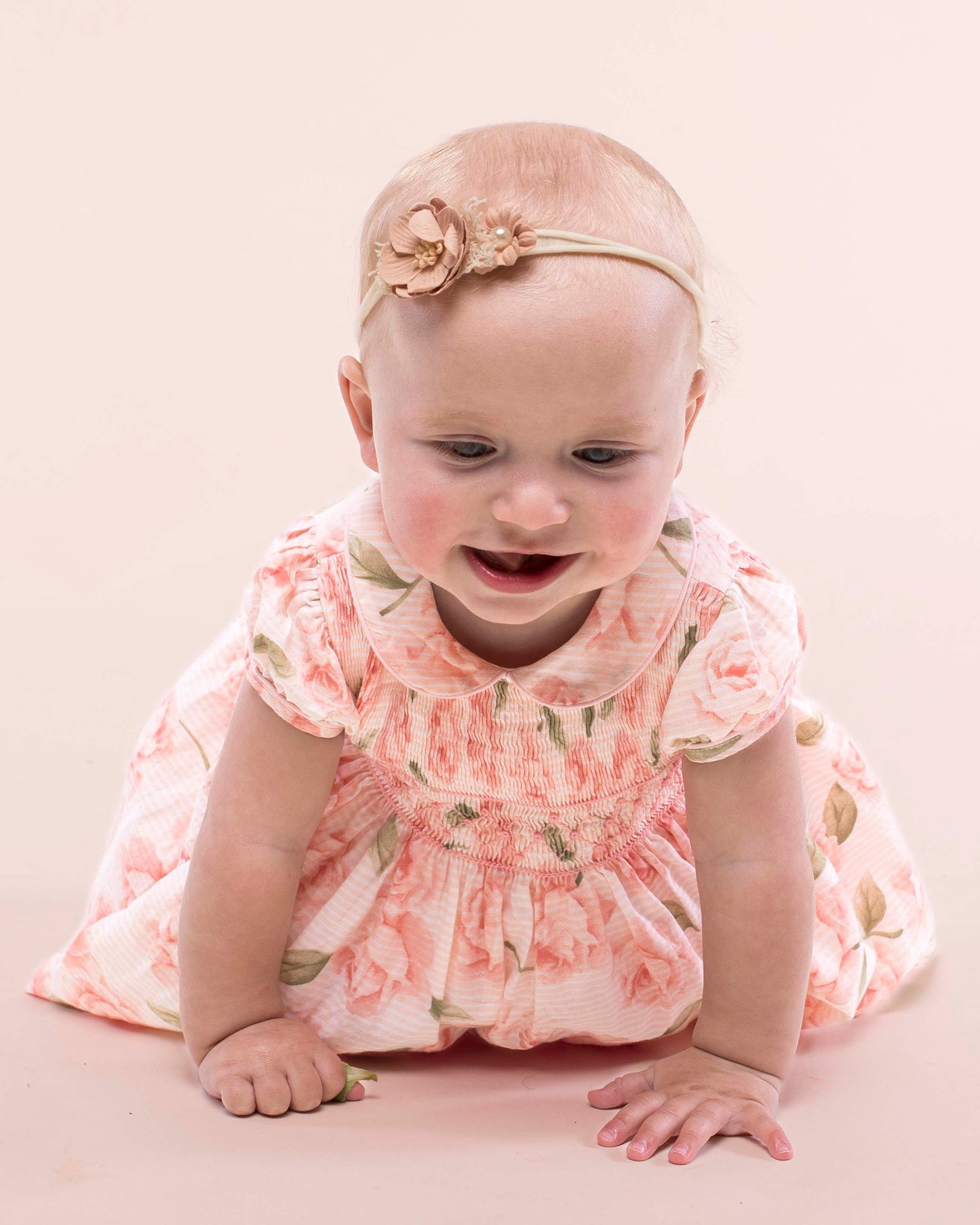 Baby girl smiling while wearing Amanda Bianca rose smock dress
