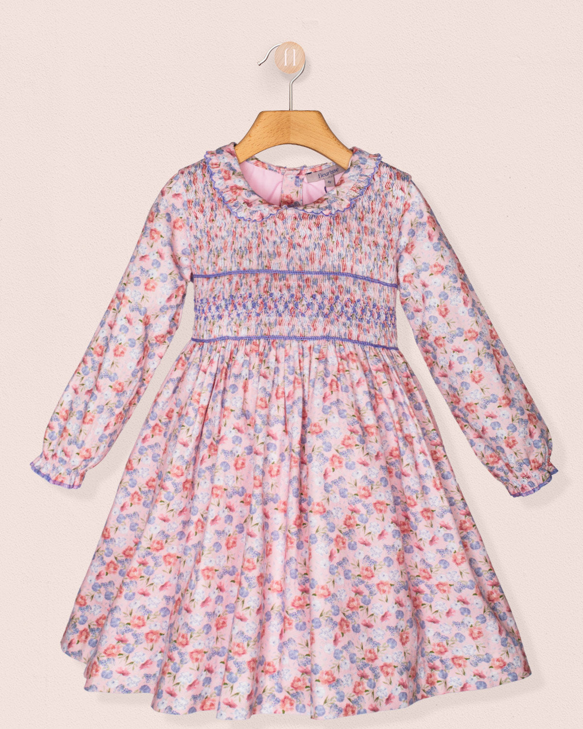 Floral dress on a hanger against a light background