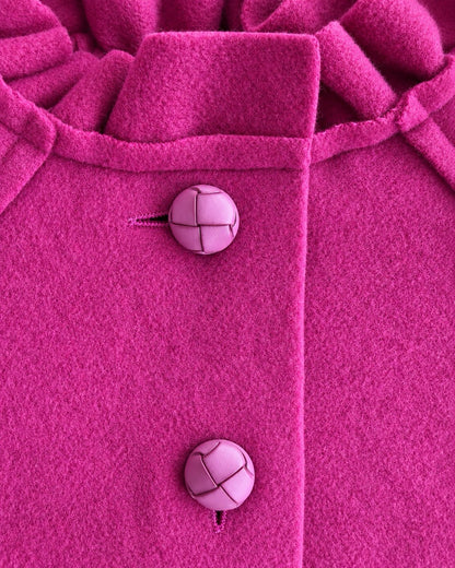 Closeup of a redish purple coat showing 2 buttons and collar