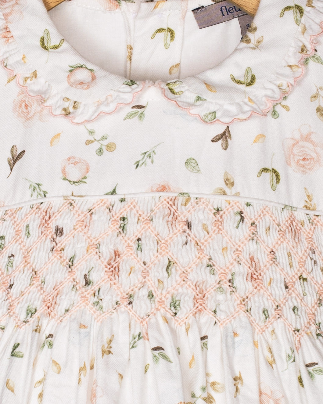 Close-up of the smocked bodice and scalloped Peter Pan collar of the Valentina dress, highlighting the delicate floral print and soft pastel embroidery details.