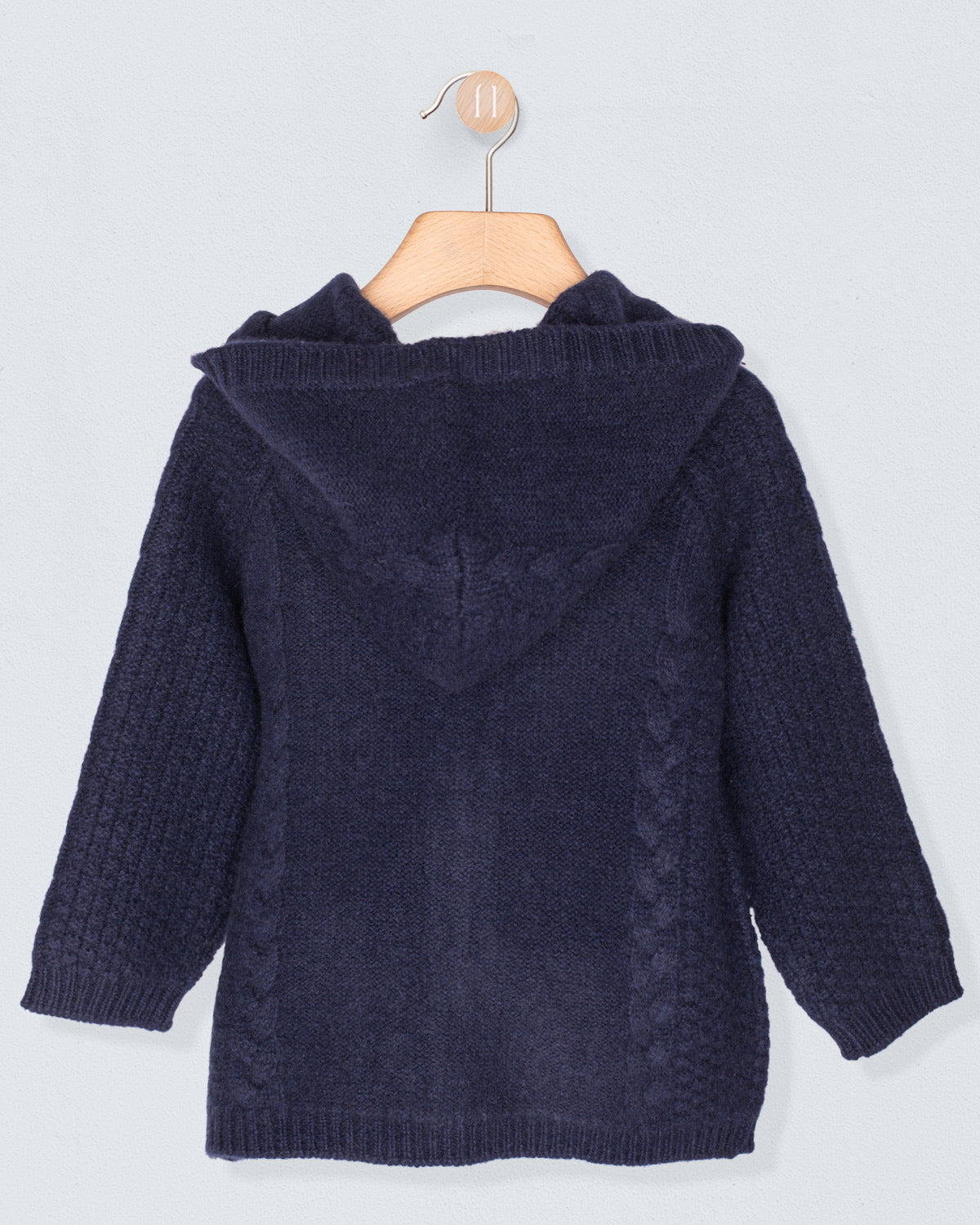 Navy blue knitted cardigan on a hanger against a light gray background