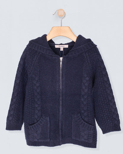 Navy blue knitted hoodie on a wooden hanger against a light gray background