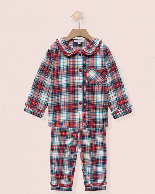 Plaid pajama set on a hanger against a light pink background