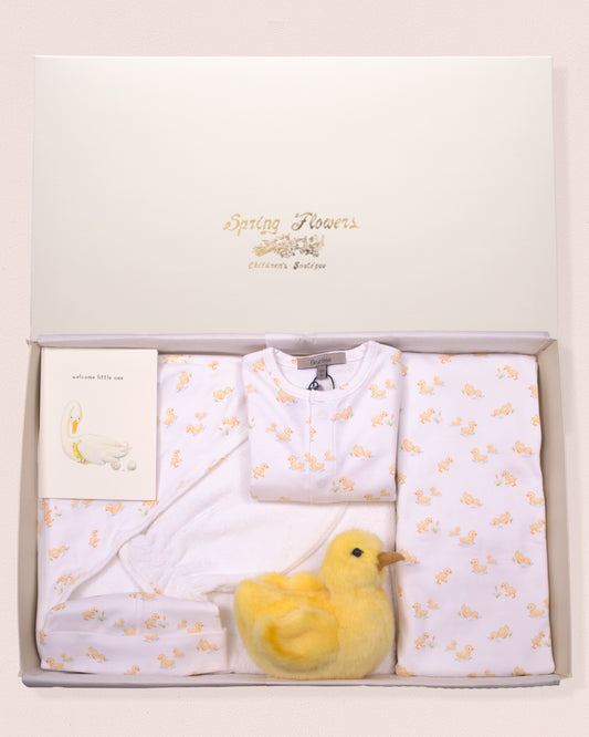 Baby gift set with white baby clothes and a yellow duck toy in a box.