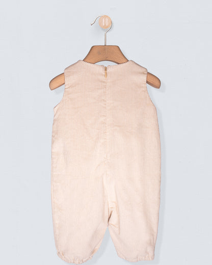 Beige baby romper on a hanger against a light gray background