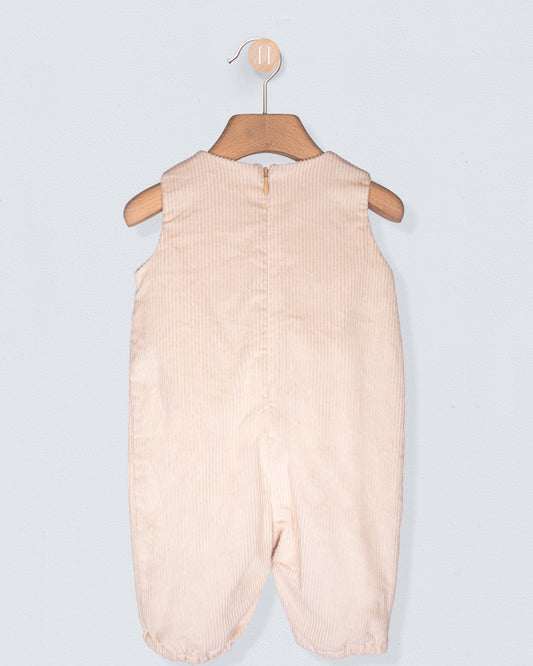 Beige baby romper on a hanger against a light gray background