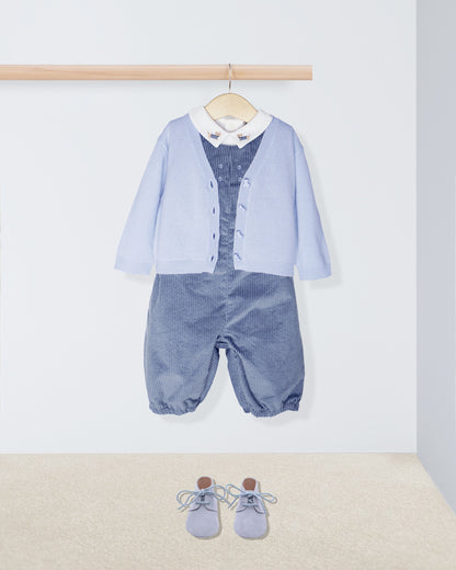 Baby outfit with blue cardigan, shirt, and pants on a hanger against a white background.